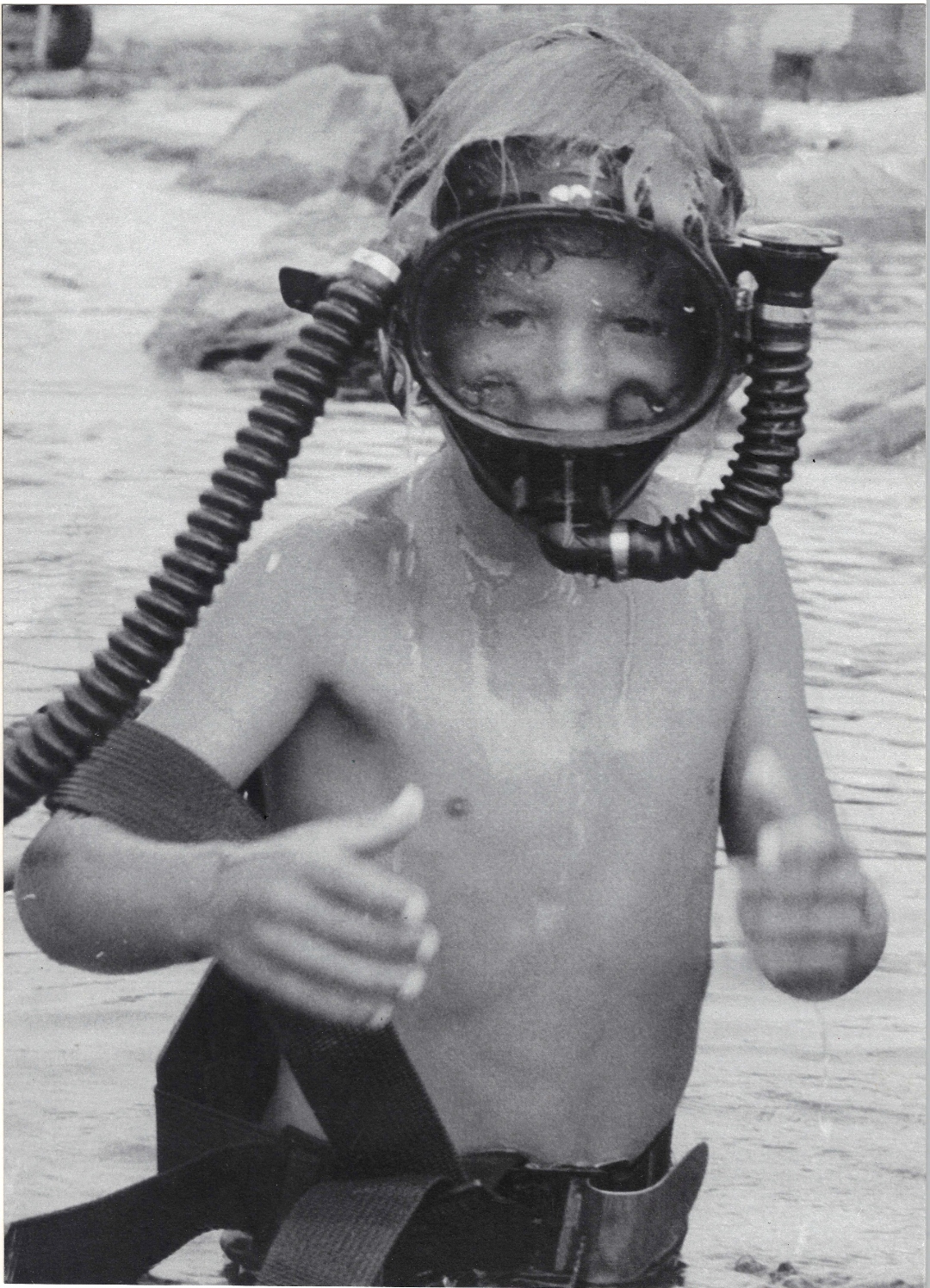 Young Ernie Kovacs in an early scuba diving mask, giving a thumbs up in the water